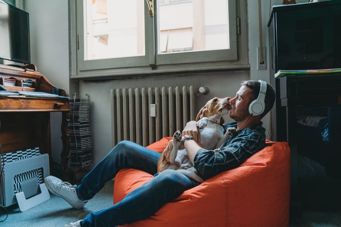 A person and a dog sit on a beanbag chair.