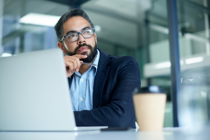 A person with a serious expression at a laptop.