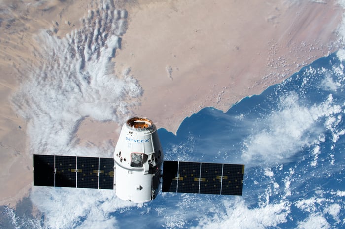 SpaceX Dragon Capsule in orbit over Earth.