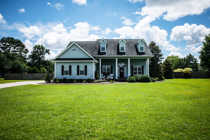 A house with a large front lawn.