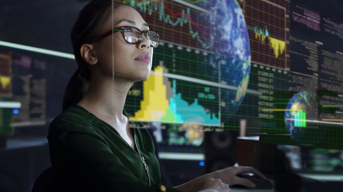 A person reviews global data which is projected on a see-through display.