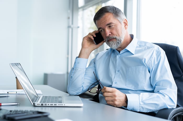 A person on the phone at a laptop.