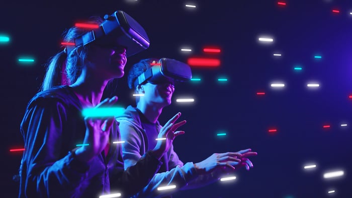 Two people wear VR headsets.