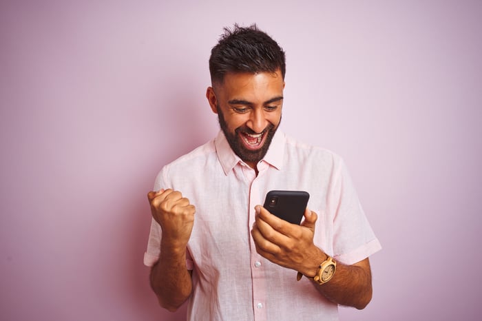 A person smiling at their phone.