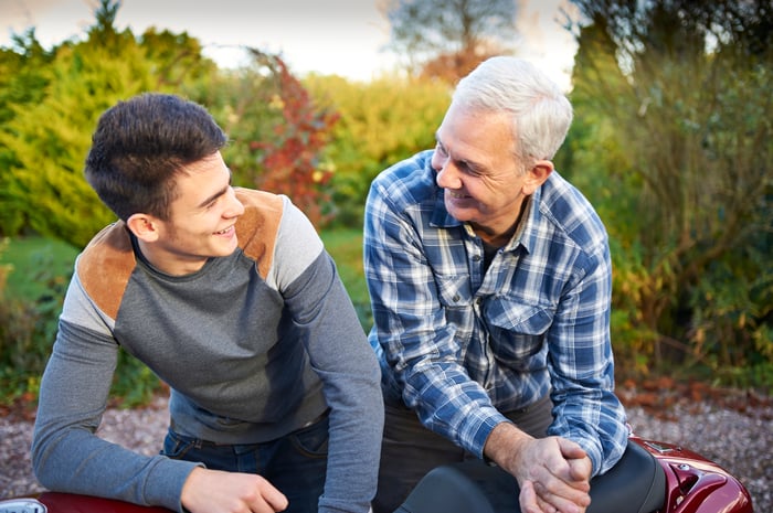 A young person sitting beside an older person.