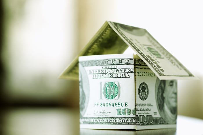 A house comprised of folded one hundred dollar bills. 