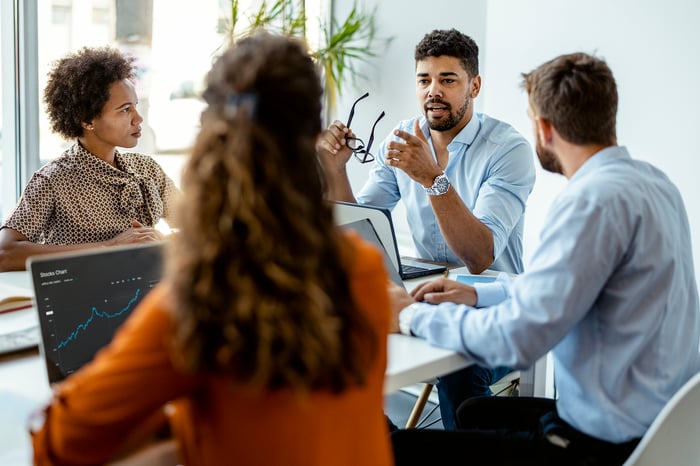 People sitting around table in conference room.