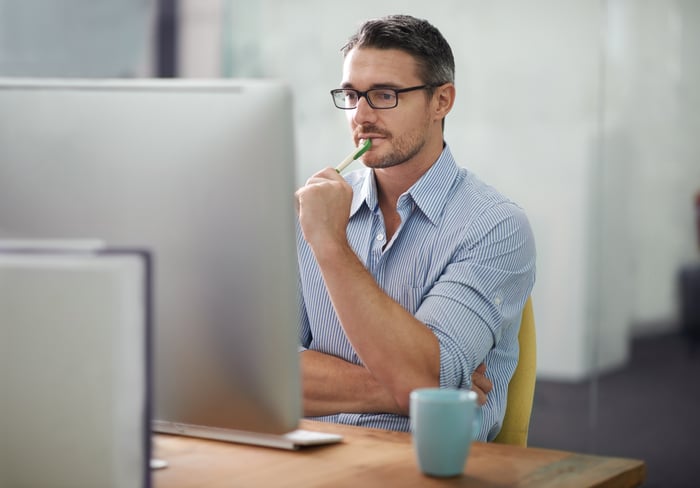 A person looking at a large computer screen.