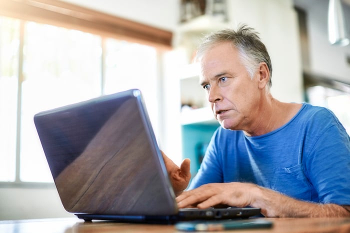 A person with a surprised expression at a laptop.