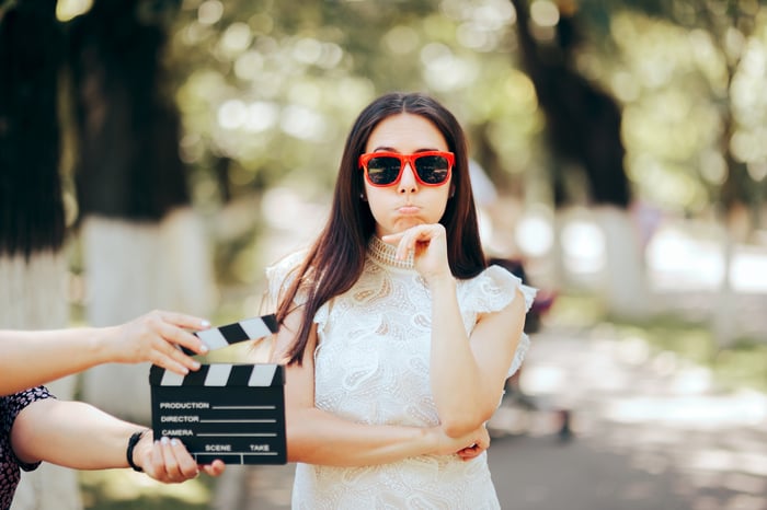 A person acting in a movie films a scene outside.