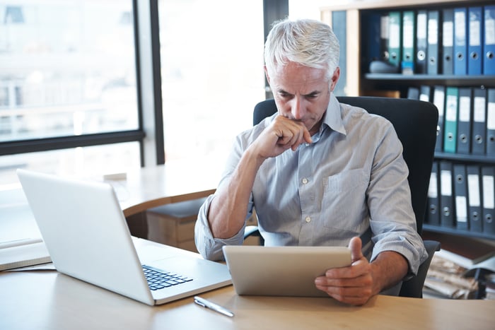 A person with a serious expression at a desk.