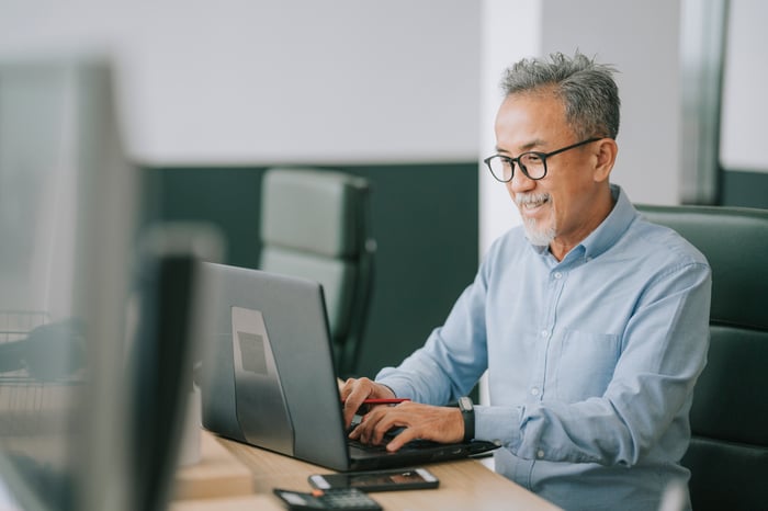 Someone using a laptop in an office.