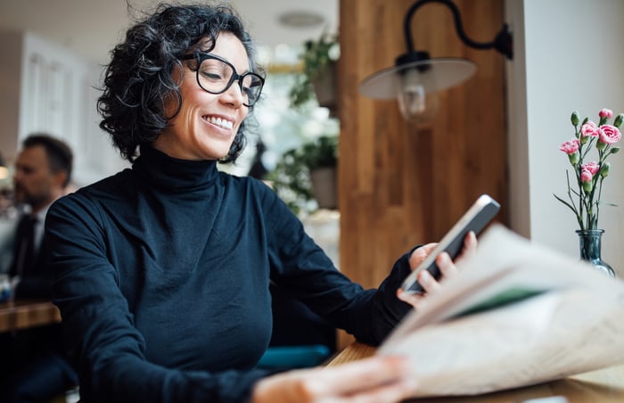 A person smiling at their phone.