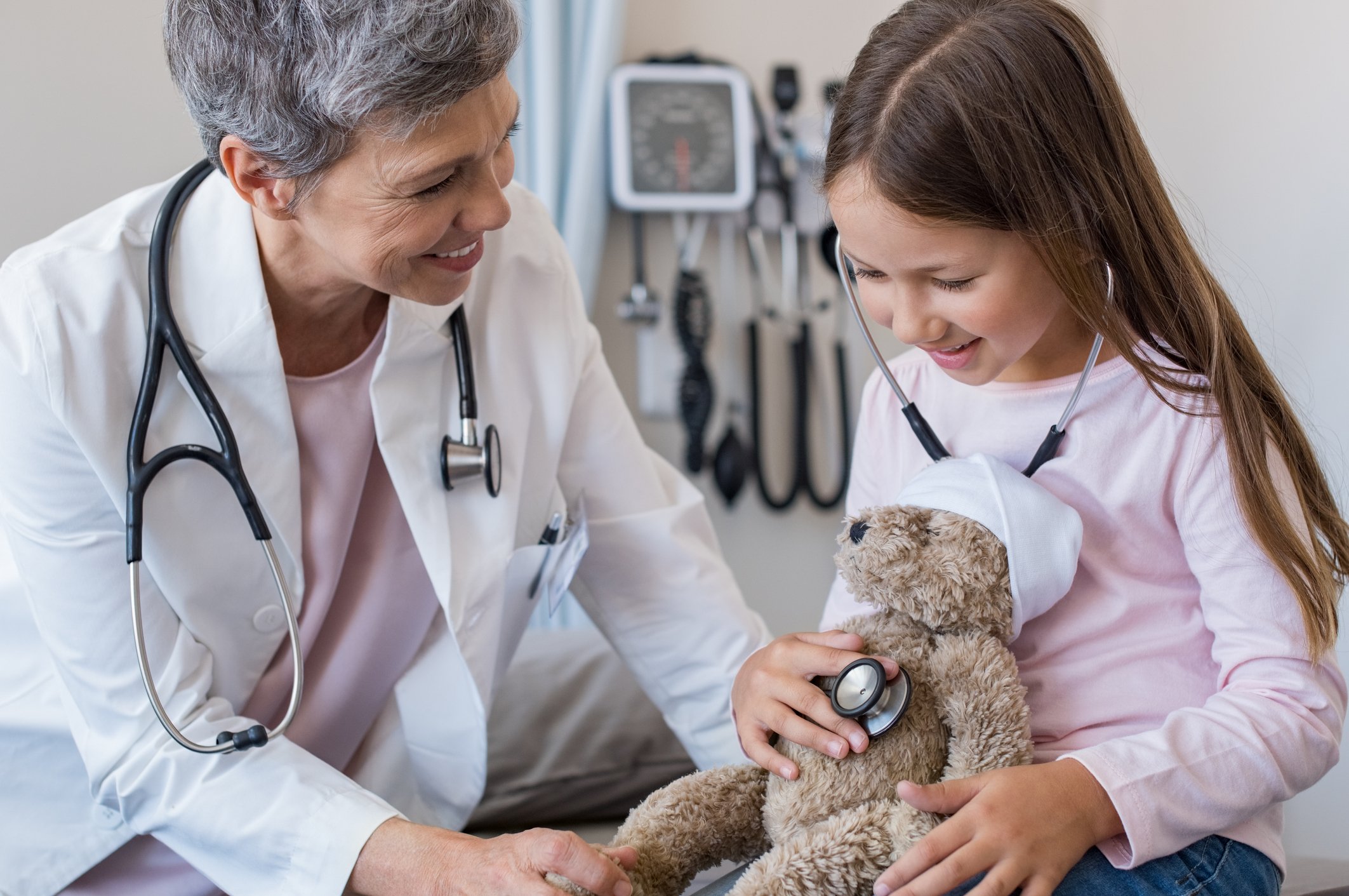 young patient with doctor listening to heart rate of stuffed bear