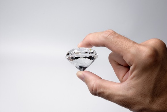 Person holding a large diamond.