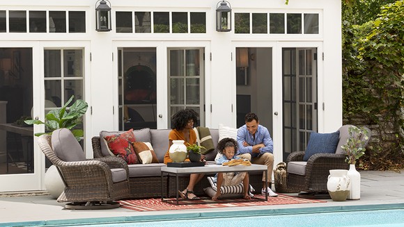 Family sitting on patio furniture.