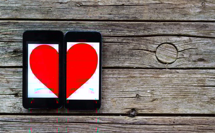 The shape of a heart is displayed across two mobile phones. 