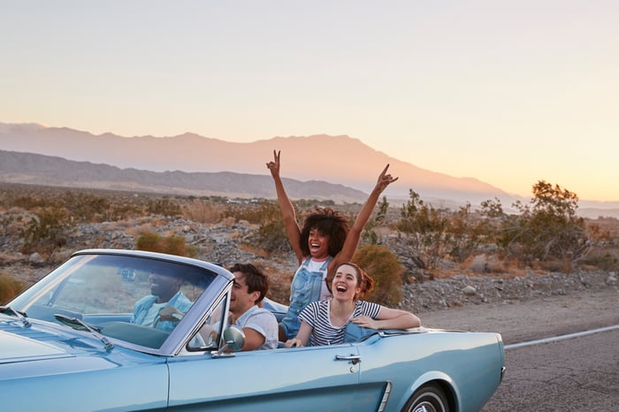 Friends are riding in a car on a road trip.