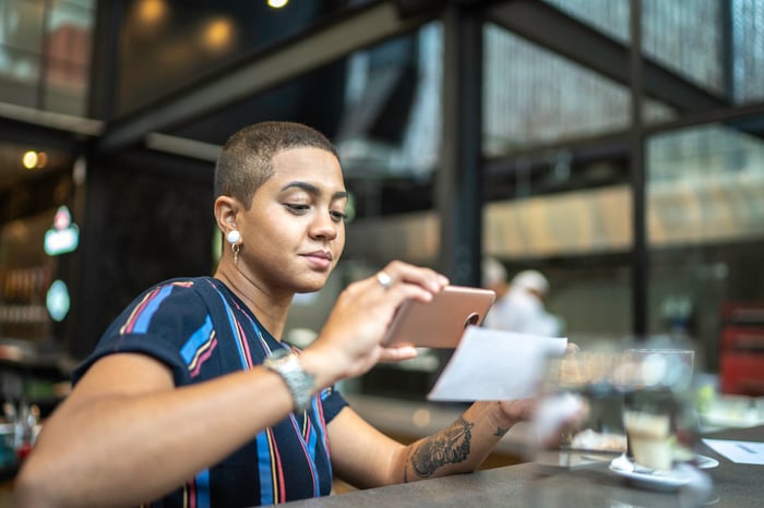 Person holds up smartphone and check to make a remote banking deposit.