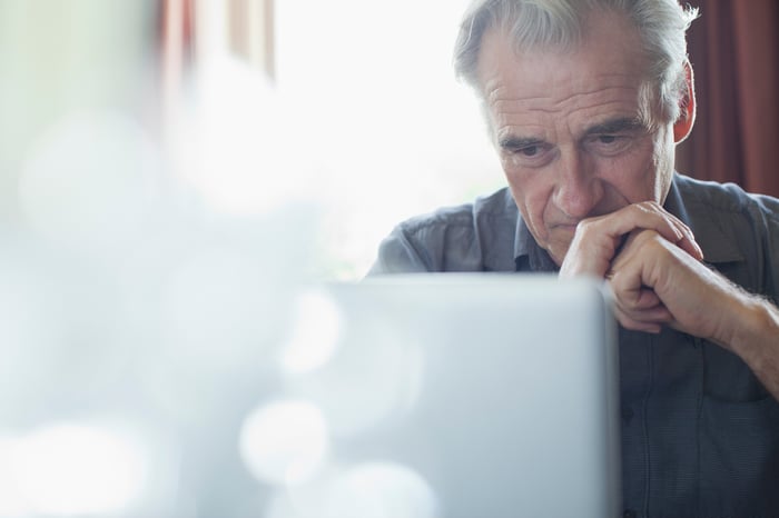 A person with a serious expression at a laptop.