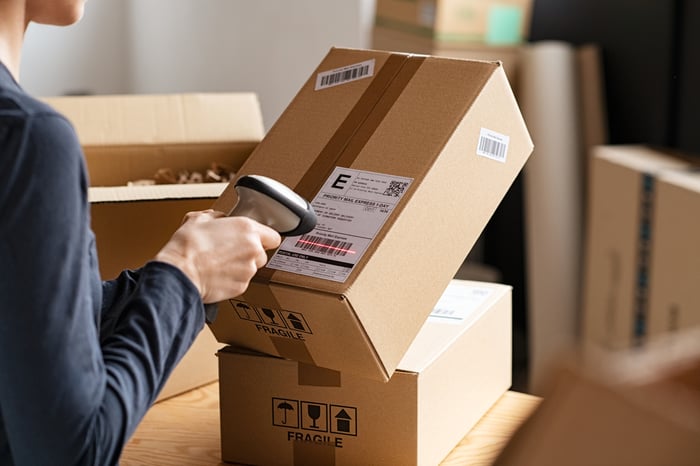 A person scanning a package.