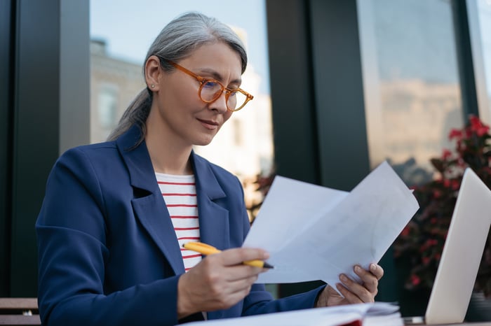 A seated person looking at documents.