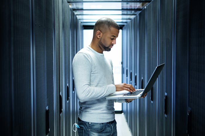Person using a laptop while standing.
