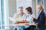 Couple talking to an investment advisor -- GettyImages-896461064