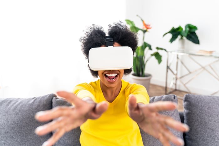 A person wearing a virtual reality headset who's reaching out with their hands. 