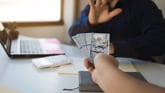 Person turning down cash in a business setting -- GettyImages-1372959868