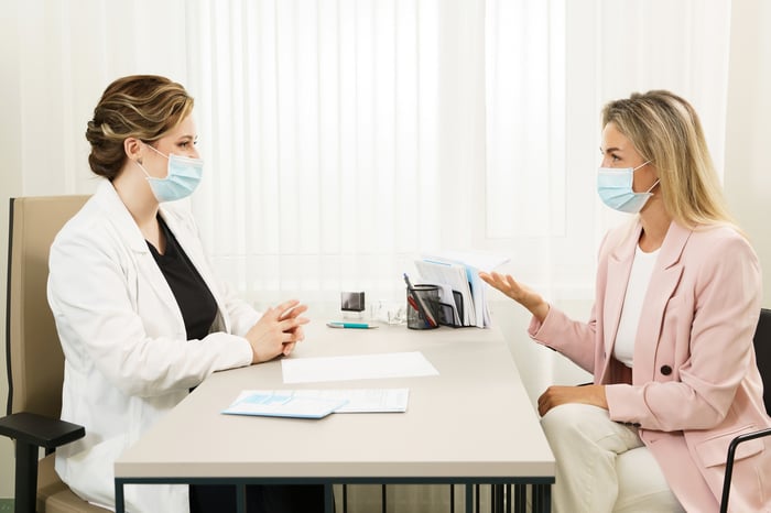 A patient and doctor speak with each other during an appointment.