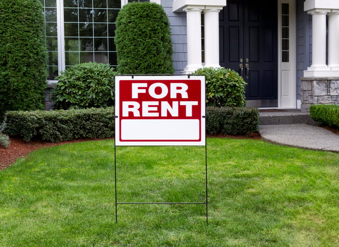 A house with a for rent sign on its lawn.