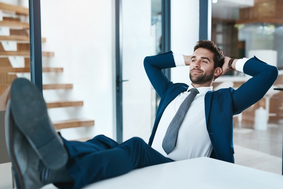 Satisfied man leaning back in chair with his feet up.