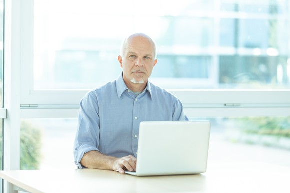 A person with a serious expression at a laptop.