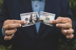 Person ripping apart a $100 Bill -- GettyImages-1352671758