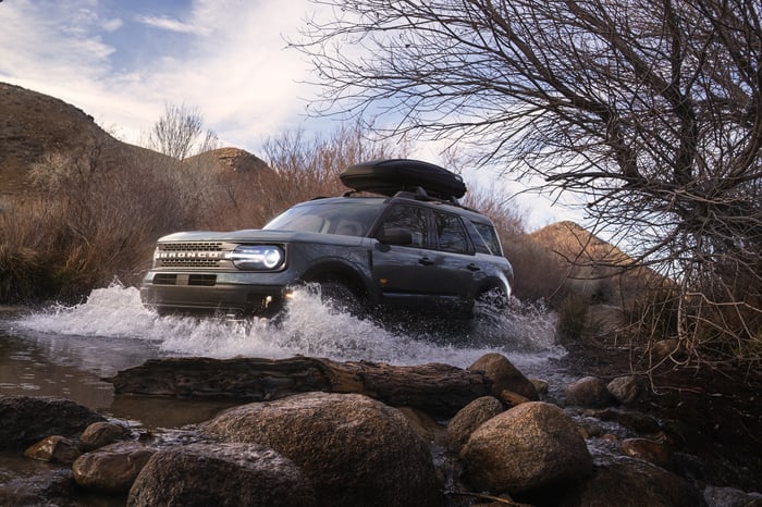 A Ford Bronco Sport driving through shallow water.
