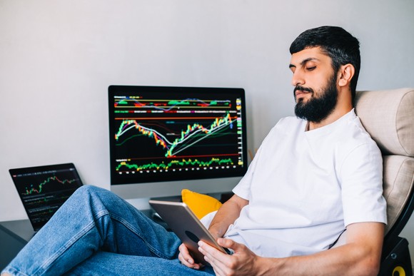 Tech investor researches stocks on multiple screens.
