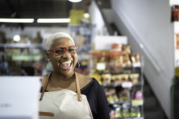 A smiling person wearing an apron.