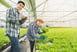 A couple working inside of a greenhouse.