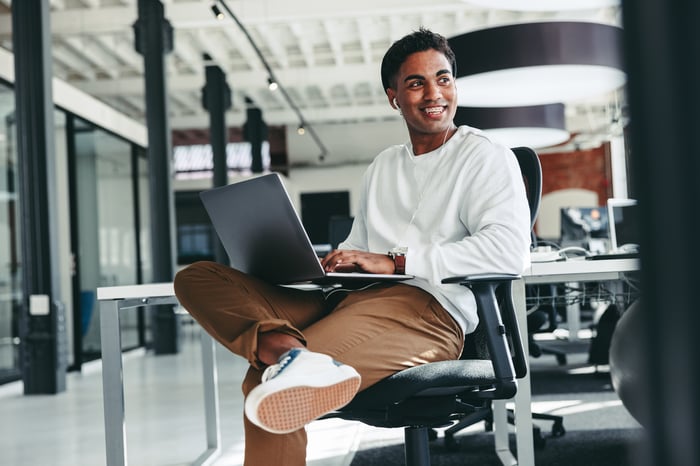Young person works on laptop at office