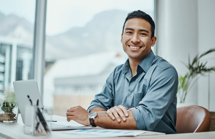 A person at a laptop smiling.