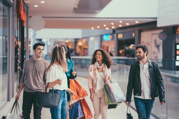 People walking with shopping bags walking in a mall.