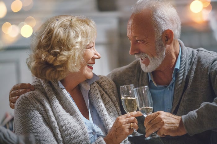 Smiling couple clinking champagne glasses together.