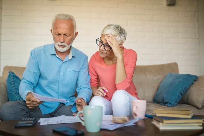 Two people with serious expressions looking at documents.