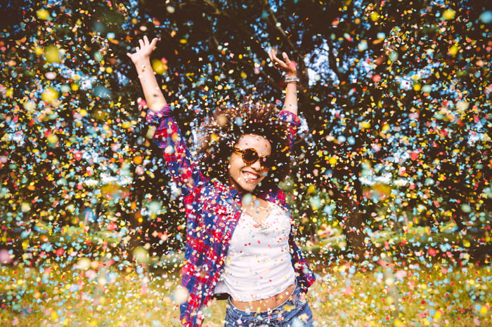 Person being showered with confetti while outdoors.