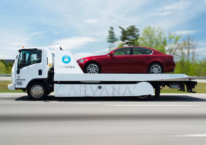 Carvana delivery truck carrying a passenger car.