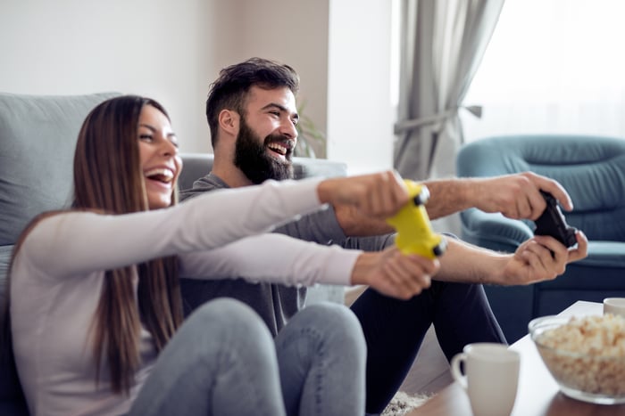 Two people play a video game at home.