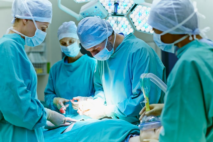 A surgical team performs surgery on a patient.