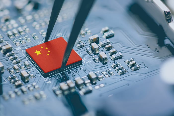 Tweezers on a Chinese flag on a processor board.