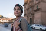A person on a city street, smiling.